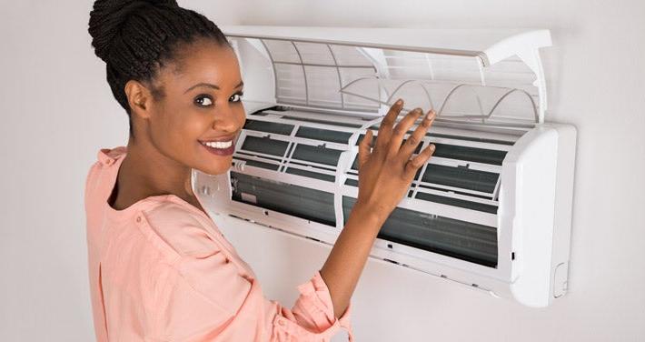 woman opening air conditioner at home